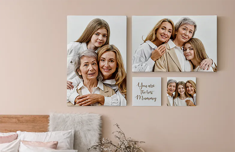 Photo Canvas Display Panels by Printerpix|Canvas Display Panels|Man and woman putting up a photo canvas with a holiday photo on|Woman putting up three black and white family photo canvases|Mom and four young kids sitting on sofa in front of four photo canvases|Couple in front of blue wall with nine square photo canvases on|||||