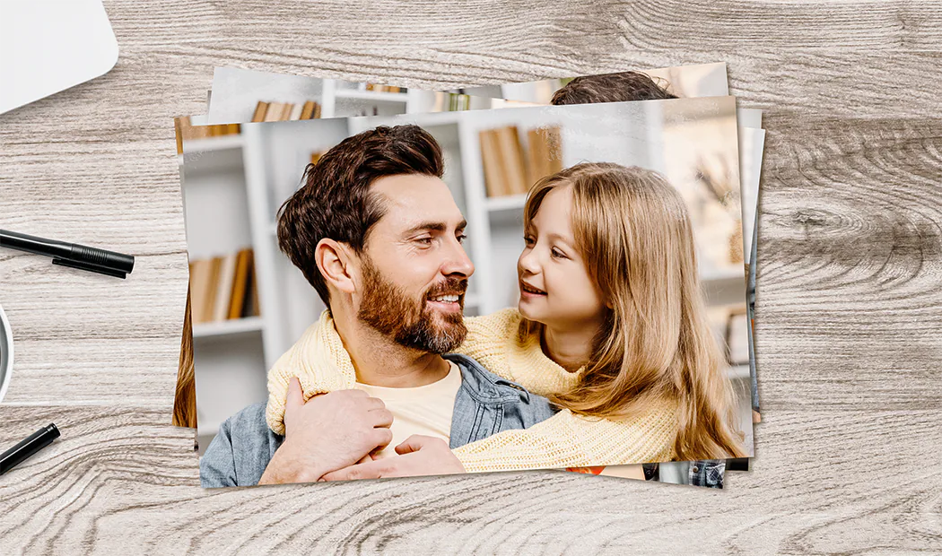 Photo Printing by Printerpix|Stack of custom photo prints from the Printerpix online photo printing service|Small medium and large photo prints on table from mobile phone|Photo Prints|Hands holding a photo print of three kids on holiday|Range of sizes of online photo prints of photos taken by mobile phone of family|||||